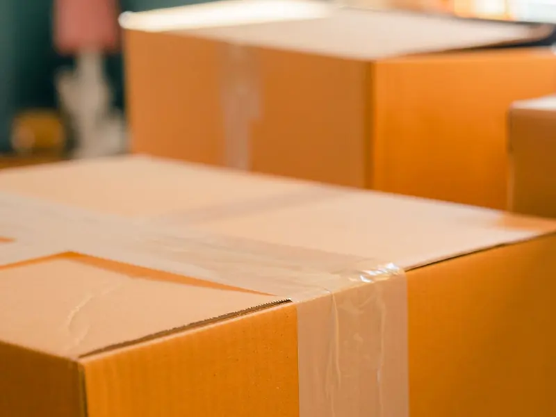Sealed moving boxes stacked by a sunny window