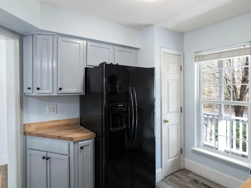 Kitchen with a black refrigerator and white cabinets
